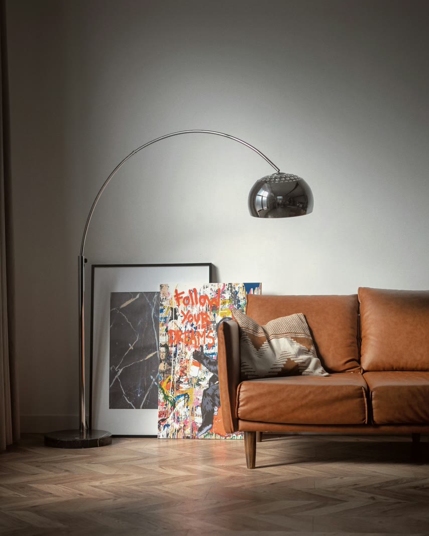 Leather sofa beside a chrome arc floor lamp